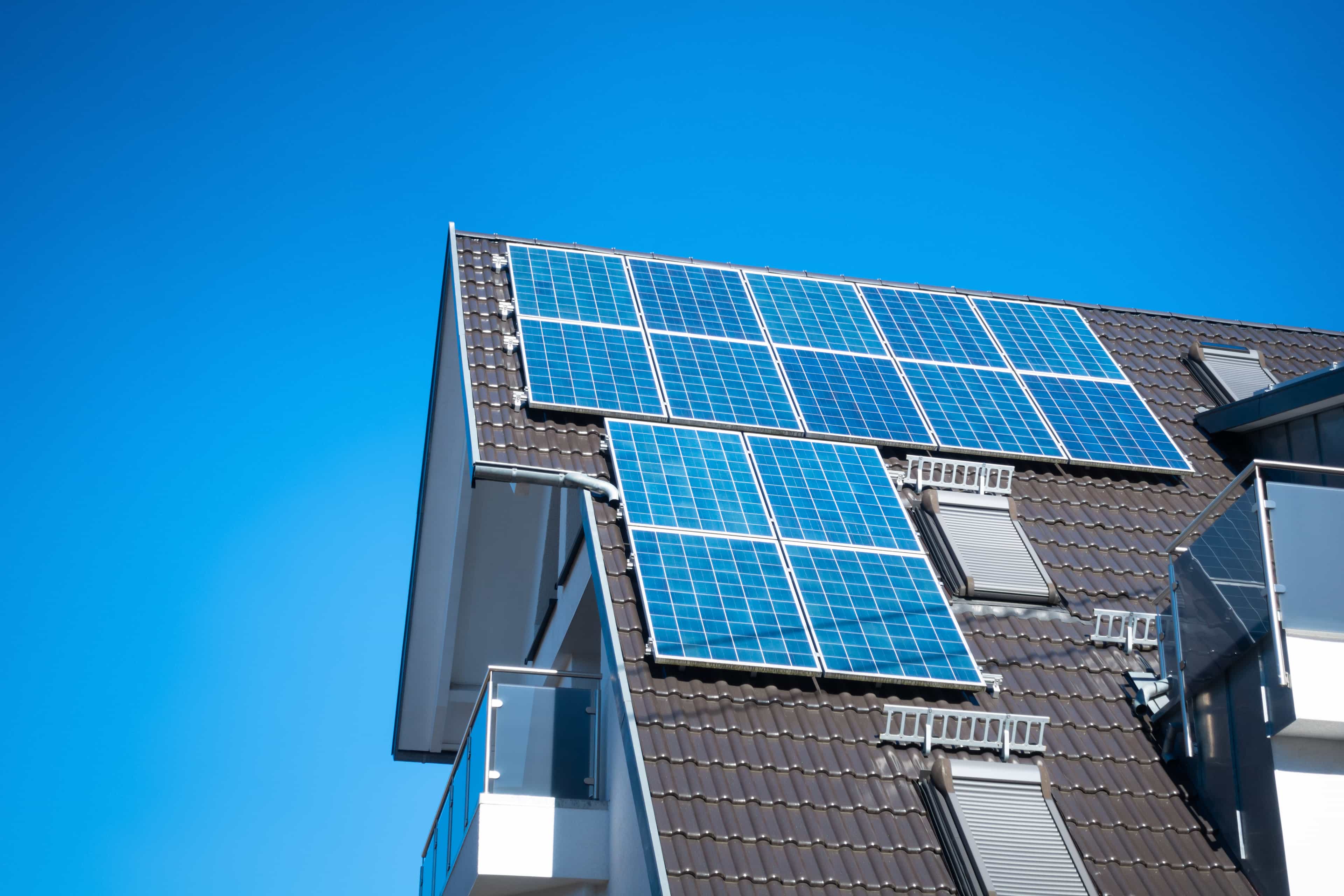 Some solar panels on the roof of a modern house