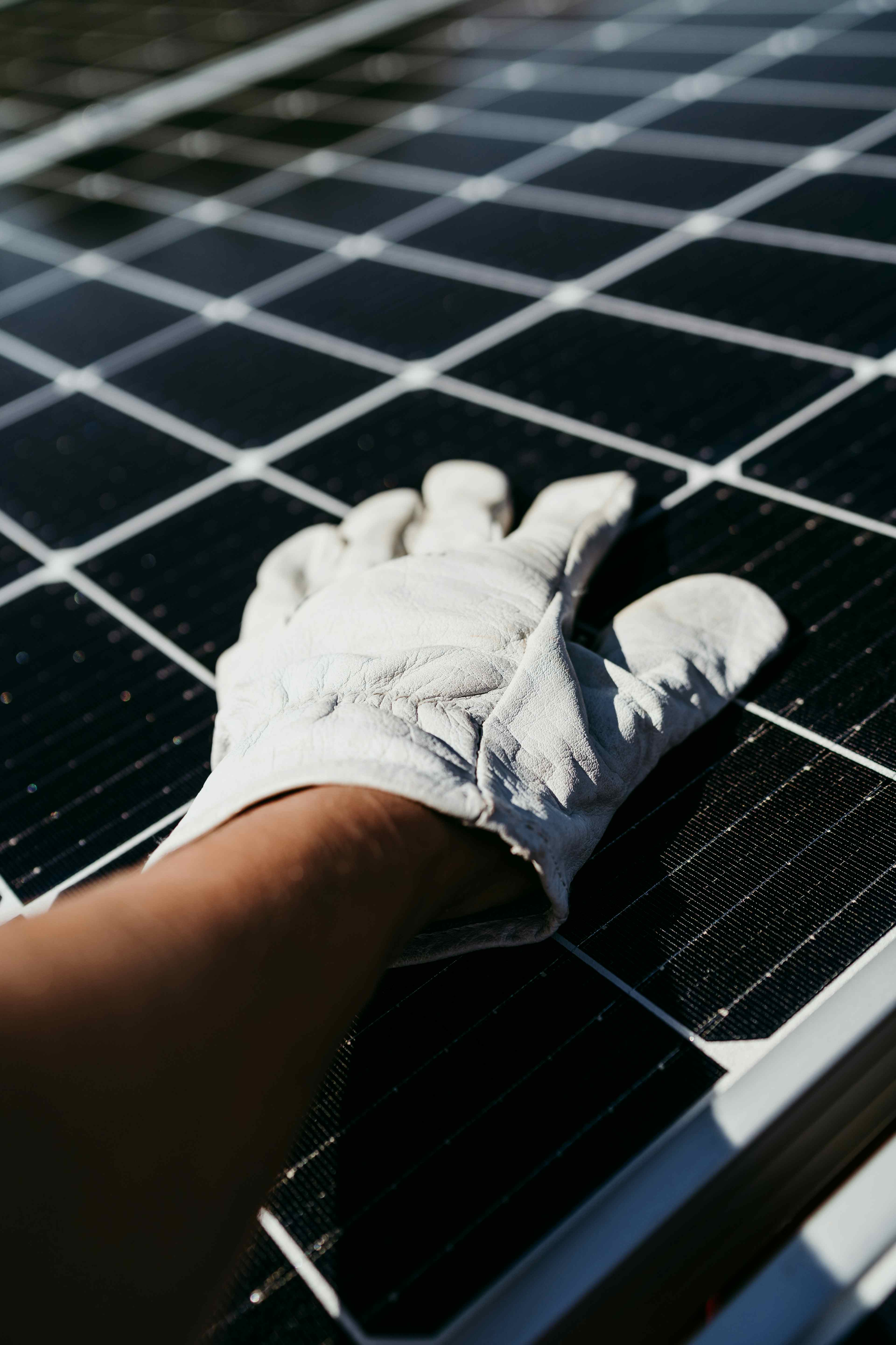 Hand of technician touching solar panel