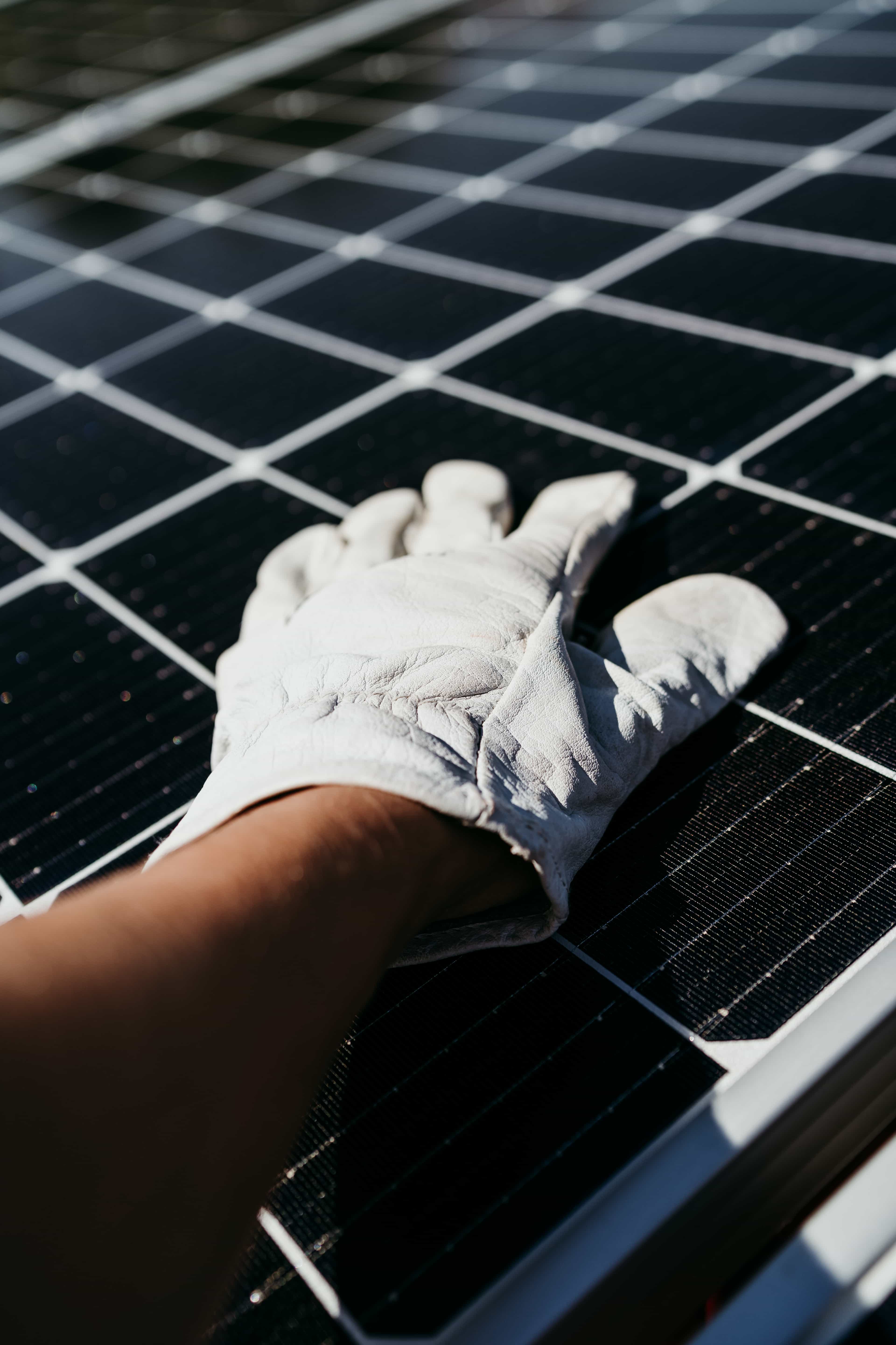 Hand of technician touching solar panel