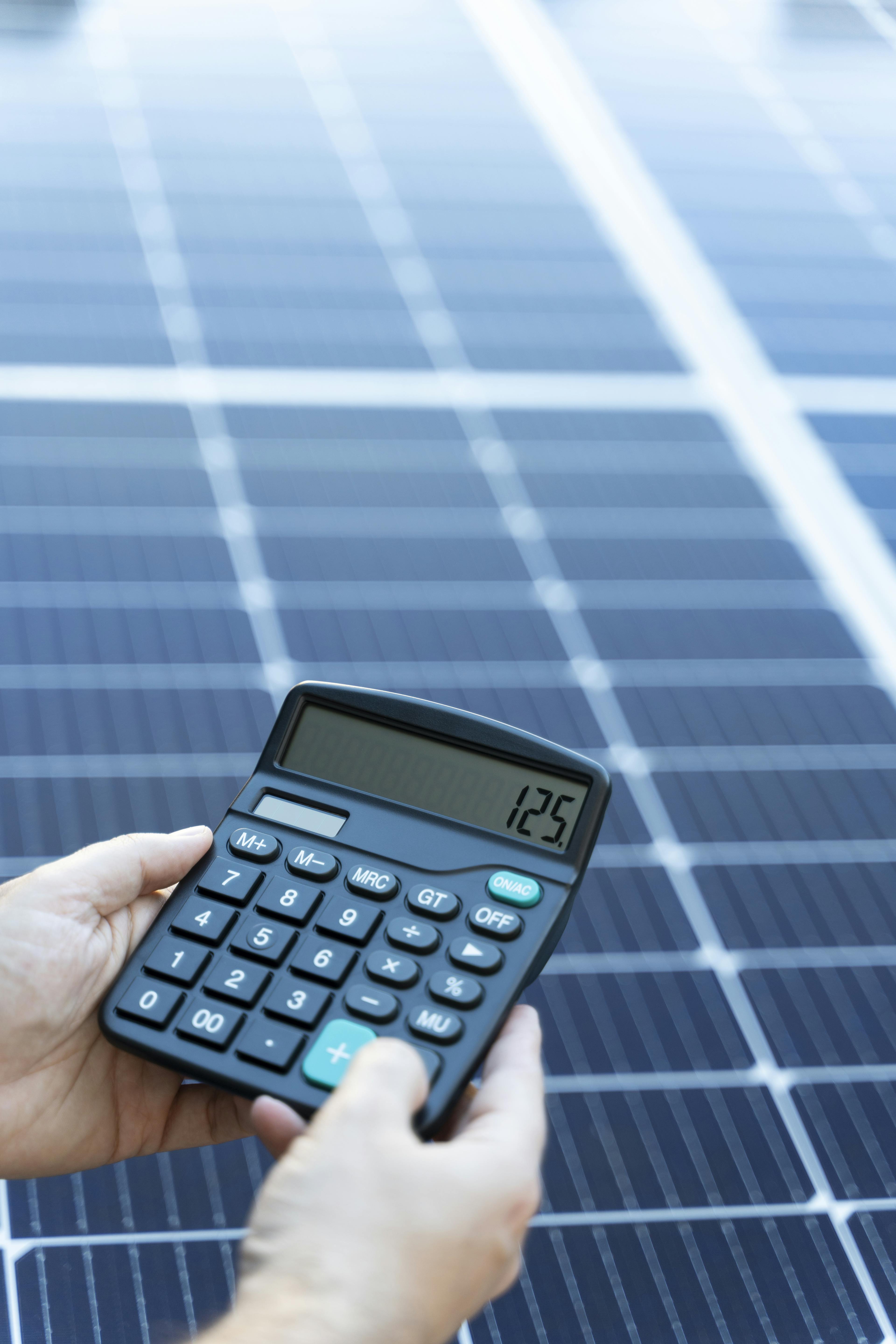 Solar panel with a person holding a calculator